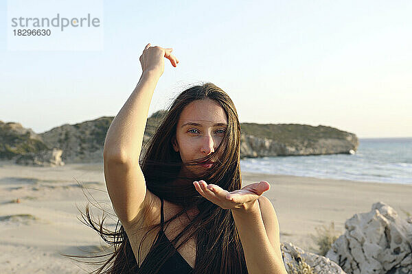 Junge Frau posiert mit langen Haaren und gestikuliert am Strand  Patara  Türkei