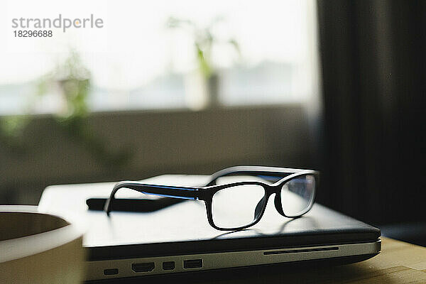 Glasses on laptop in office