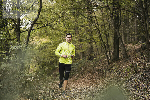 Aktiver reifer Mann joggt im Wald