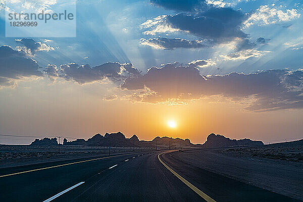 Saudi-Arabien  Al-Ula  Sonnenuntergang über einer leeren Autobahn