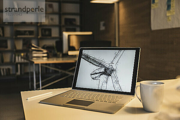Laptop mit Windkraftanlage auf dem Bildschirm am Schreibtisch im Büro