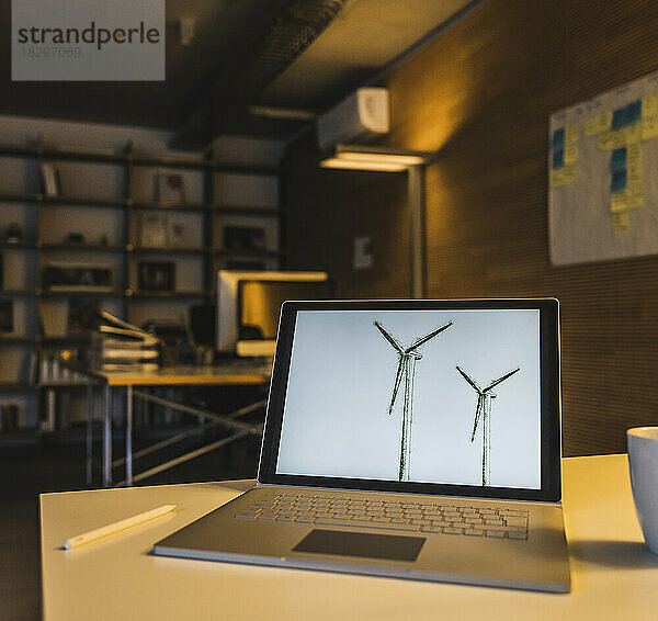 Laptop mit Windkraftanlagen auf dem Bildschirm am Schreibtisch