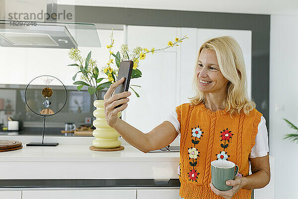 Glückliche Frau  die zu Hause ein Selfie mit dem Smartphone macht