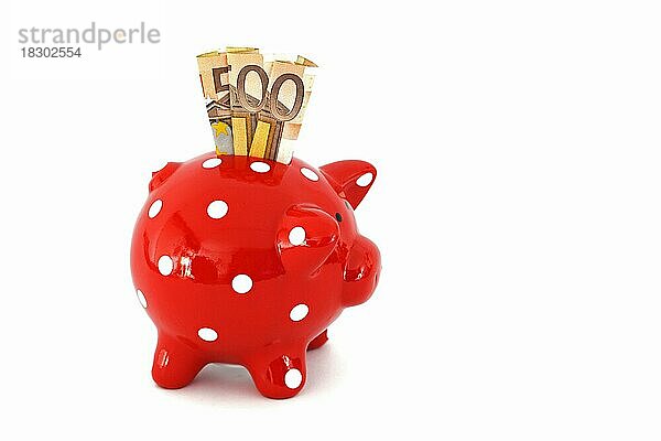 Rotes Sparschwein mit weissen Punkten und 50 Euro Banknoten  freigestellt  Freisteller