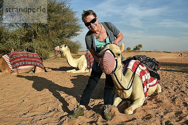 Frau und Kamel in einer Sandwüste  Dubai  Vereinigte Arabische Emirate  Asien