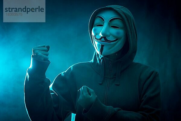 Hacker mit anonymen Maske mit einer Herstellung Kampf Symbol  mit einem Hintergrund von Rauch