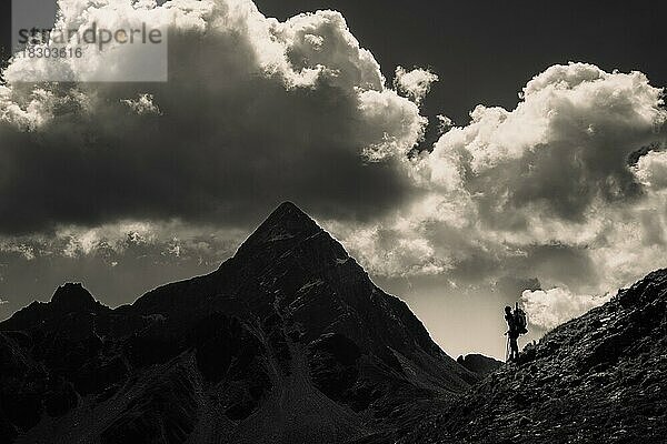 Markanter Gipfel des Piz OT mit Bergsteiger im Gegenlicht  St Moritz  Engadin  Graubünden  Schweiz  Europa