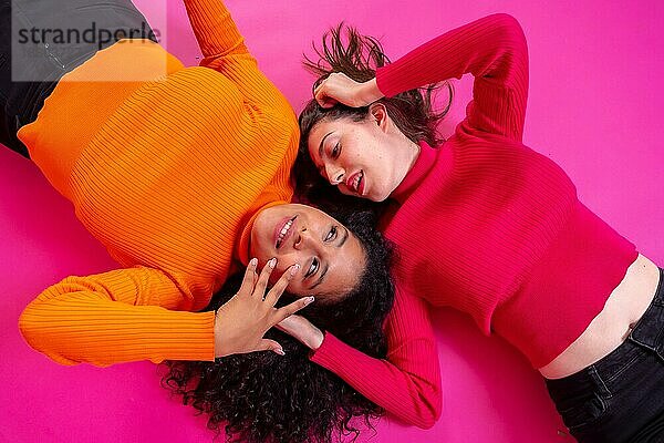 Zwei multiethnische Frauen  die glücklich auf einem rosa Hintergrund posieren  Lebensstil