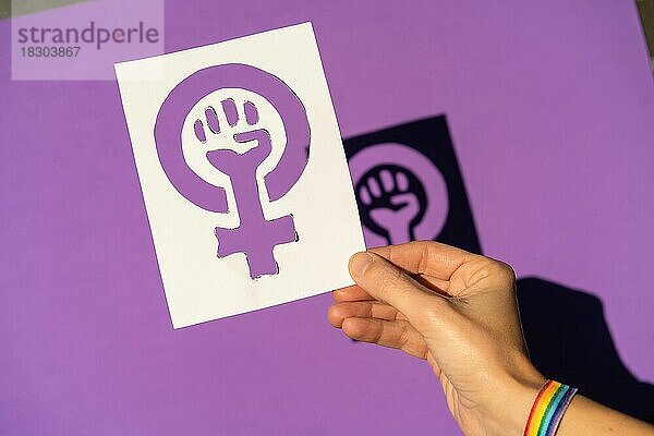 Eine Frau hält eine Zeichnung in einer Rechtfertigung zugunsten der Gleichheit zwischen Männern und Frauen  lila Hintergrund  kämpfen zugunsten der Frauen  Female Force