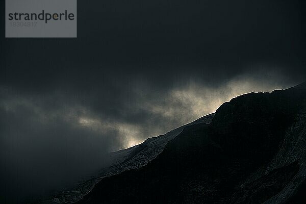 Gipfel des Piz Rosegg in dramatischen Wolken bei blauer Stunde  St Moritz  Engadin  Graubünden  Schweiz  Europa