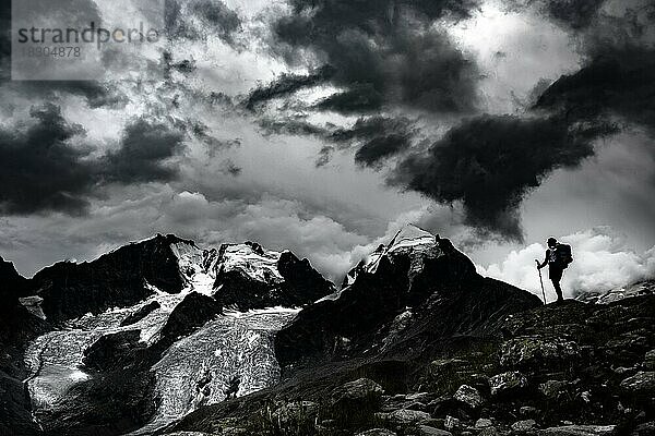 Bergsteiger vor Gipfel der Bernina Gruppe mit dramatischen Wolken  St Moritz  Engadin  Graubünden  Schweiz  Europa