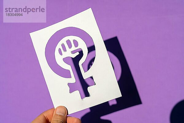 Symbol des Kampfes des Feminismus auf einem lila Hintergrund  geballte Faust einer Frau im Marsch Proteste für die Rechte der Frauen