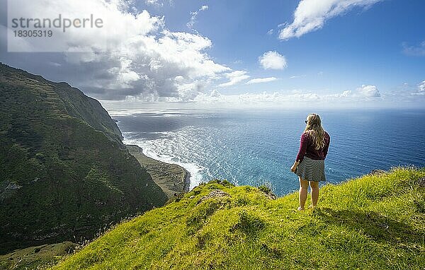 Junge Frau genießt Ausblick auf Steilküste mit Klippen und Meer  Küstenlandschaft  Aussichtspunkt Ponta da Leideira  bei Calhau das Achadas  Madeira  Portugal  Europa