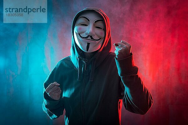 Hacker mit anonymen Maske mit einem Symbol des Kampfes  mit einem Hintergrund von Rauch und farbigen führte