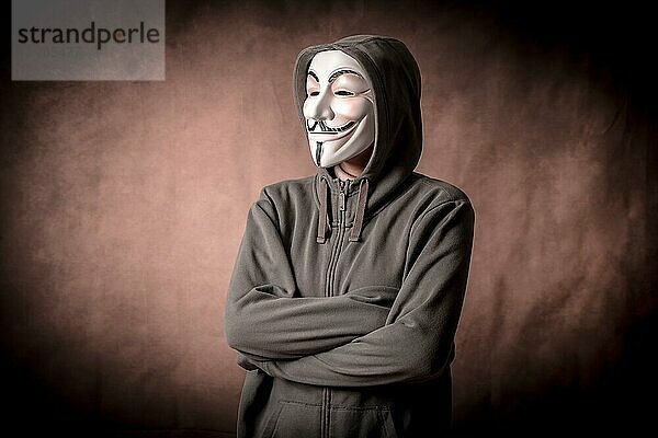 Mann mit anonymer Maske und Sweatshirt  Blick nach links  Studioaufnahme