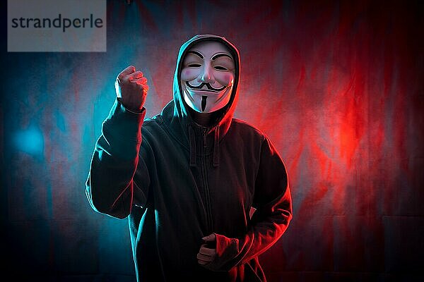 Hacker mit anonymen Maske mit seiner Faust in Symbol des Kampfes  rot und blau Hintergrund erhoben