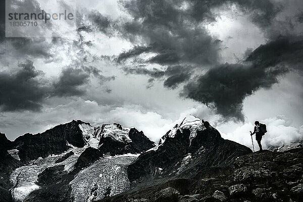 Bergsteiger vor Gipfel der Bernina Gruppe mit dramatischen Wolken  St Moritz  Engadin  Graubünden  Schweiz  Europa