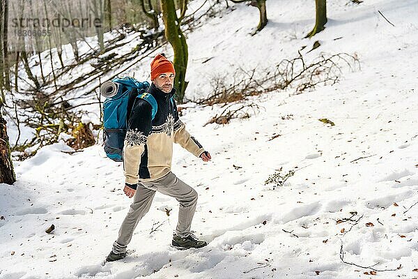 Wanderer Mann auf einem Trekking auf dem Schnee  Winterabenteuer  natürliche Aktivität