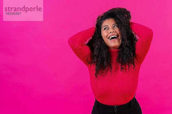 Gelockte Frau lächelnd auf einem rosa Hintergrund  Studioaufnahme  Lifestyle
