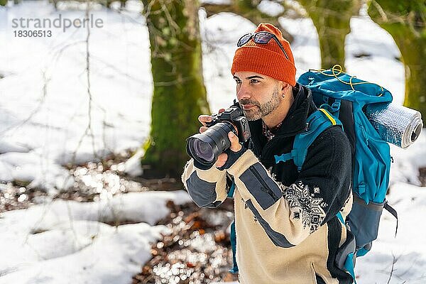 Fotograf beim Fotografieren im Winter in einem verschneiten Wald