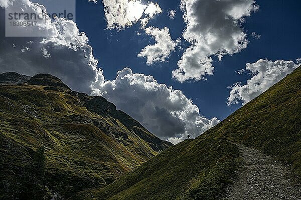 Bergpfad mit Bergsteiger im Val Belver mit Wolkenhimmel  St Moritz  Engadin  Graubünden  Schweiz  Europa