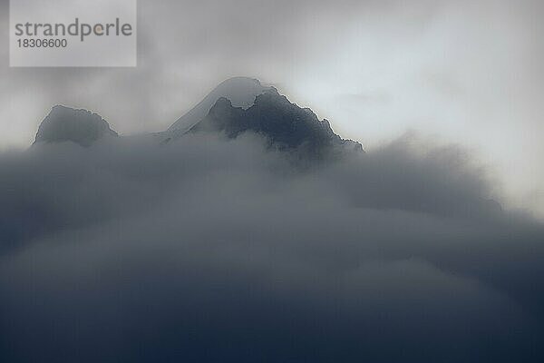 Gipfel des Piz Rosegg in dramatischen Wolken bei blauer Stunde  St Moritz  Engadin  Graubünden  Schweiz  Europa