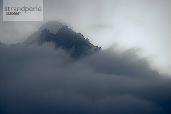 Gipfel des Piz Rosegg in dramatischen Wolken bei blauer Stunde  St Moritz  Engadin  Graubünden  Schweiz  Europa