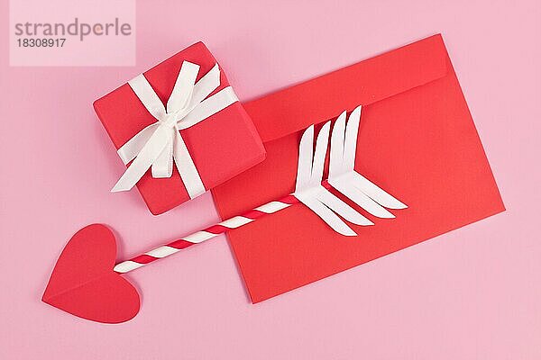 Nette Papier Amor Liebe Pfeil mit herzförmigen Spitze  Liebesbrief und Geschenk-Box für Valentinstag auf rosa Hintergrund