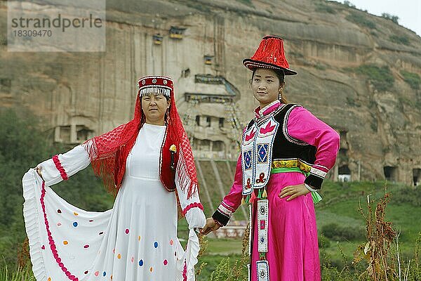 Chinesische Besucher posieren in geliehenen Trachten an den Felshöhlen des Mati Klosters  Zhangye  Provinz Gansu  China  Asien