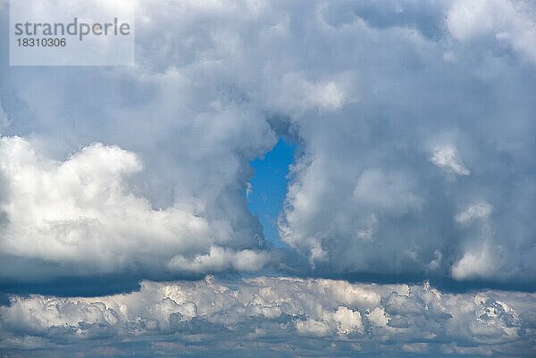 Himmel mit Cumulus-Wolken mit einer kleinen Lücke in der Bewölkung