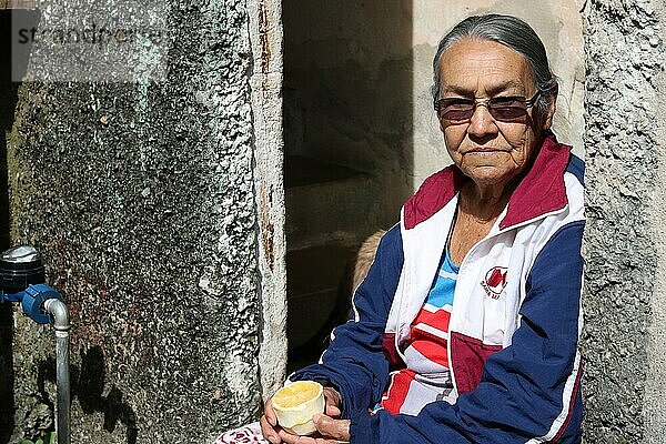 Favela  Seniorin isst eine Orange an der Tür ihres Hauses  Belo Horizonte  Minas Gerais  Brasilien  Südamerika