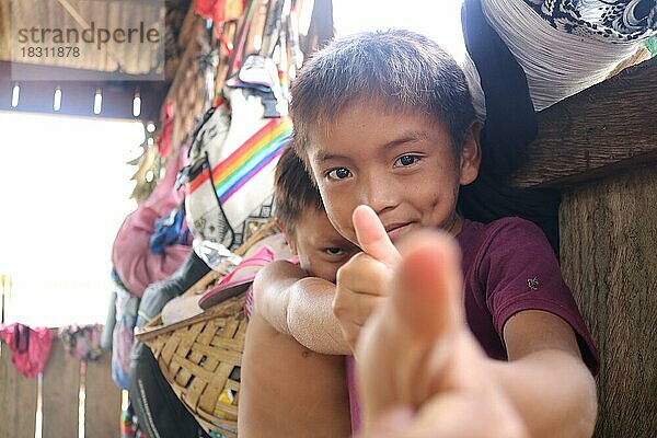 Indigenes Volk  kleine Jungen der Ureinwohner Huni Kuin machen eine lustige Geste in in ihrem Dorf im Amazonas-Regenwald  Acre  Brasilien  Südamerika