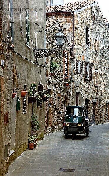 In der Altstadt von Pitigliano  kleines Auto faehrt durch die engen Gassen  Toskana  Italien  Europa