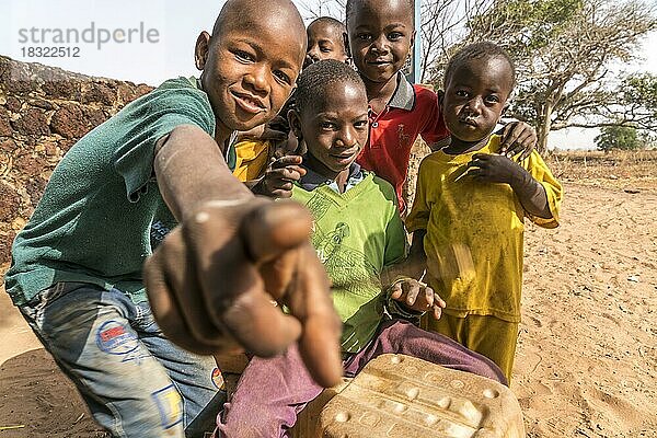 Eine Gruppe afrikanischer Kinder mit selbstgenauter Trommel beim singen und spielen  Wassu  Gambia  Westafrika  Afrika