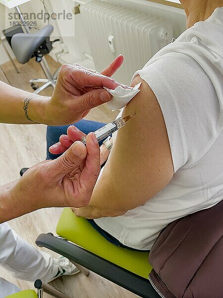 Frau lässt sich in Arztpraxis gegen Grippe Influenza impfen bekommt Grippeschutzimpfung  Deutschland  Europa