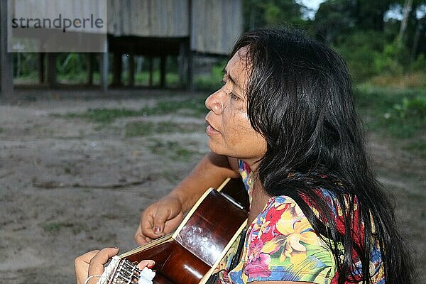 Indigenes Volk  Frau der Ureinwohner Huni Kuin spielt Gitarre und singt in ihrem Dorf im Amazonas-Regenwald  Acre  Brasilien  Südamerika
