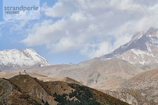 Die Gergetier Dreifaltigkeitskirche  Bergkirche Gergeti vor grandioser Hochgebirgskulisse  Gergetis Sameba  Tsminda Sameba  rechts der Gipfel des Kasbek  Region Mzcheta-Mtianeti  Großer Kaukasus  Georgien  Asien