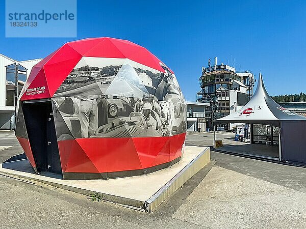 Open Air Museum Ausstellungsraum mit Ausstellung zu Rennsportgeschichte in Form von begehbarer Riesenhelm mit links Eingang außen historische Fotos von Autorennen  im Hintergrund Tower von Race Control  Rennstrecke Circuit de Spa Francorchamps  Ardennenachterbahn  Ardennen  Malmedy  Belgien  Europa