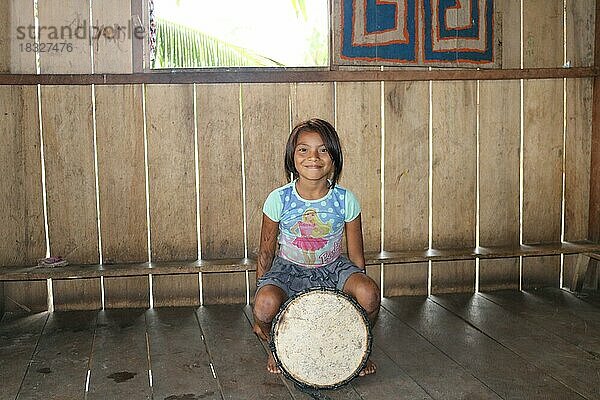 Indigenes Volk  kleines Mädchen der Ureinwohner Huni Kuin sitzt auf seiner Trommel in seinem Dorf im Amazonas-Regenwald  Acre  Brasilien  Südamerika