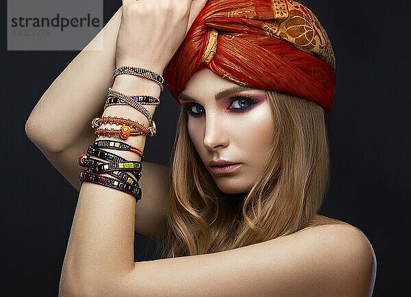 Schöne Mode Mädchen in einem Schal und Armbänder Boho-Stil. Schönheit Gesicht  helle trendy Make-up. Bild im Studio aufgenommen