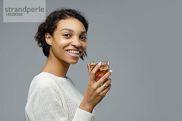 Nahaufnahme Porträt der jungen afrikanischen Frau mit einem Glas Cola mit Eis in der Hand