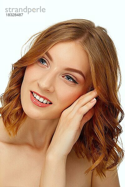 Schöne junge Frau mit blauen Augen und roten Lippen  die ihre Wange berühren. Schönheit Porträt  frische Haut. Natürliches Make-up