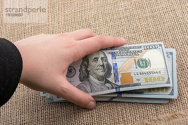 Hand hält Banknote Bündel von US-Dollar auf einem Leinen Leinwand Hintergrund