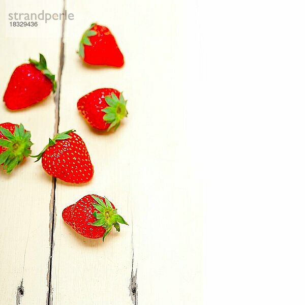 Frische Bio-Erdbeere über weißem rustikalem Holztisch