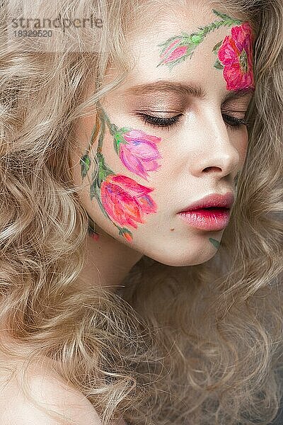 Schönes blondes Mädchen mit Locken und einem Blumenmuster auf dem Gesicht. Schönheit Blumen. Porträtaufnahme im Studio