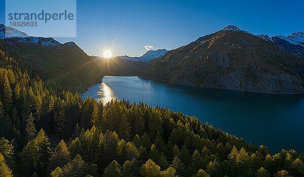 Luftaufnahme zum Sonnenuntergang über dem herbstlichen Wald am Lago di Luzzone im Valle di Blenio  Kanton Tessin  Schweiz  Europa