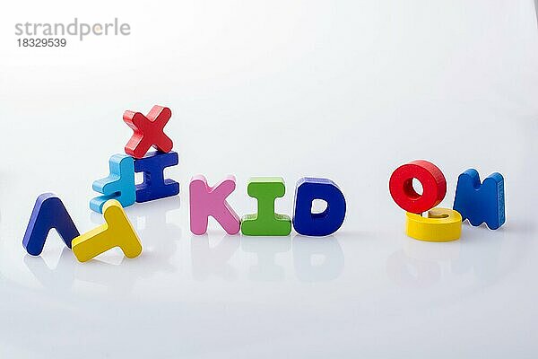 Das Wort KID geschrieben mit bunten Buchstabenblöcken auf weißem Grund