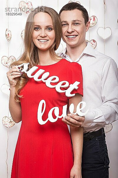 Schönes junges Paar in der Liebe mit den Worten Süße Liebe zeigt die Form des Herzens Hände. Valentinstag. Bild im Studio aufgenommen