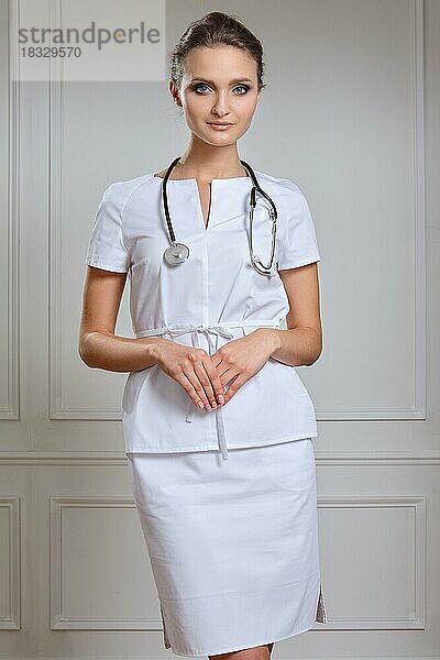 Schöne Ärztin in weißer Uniform. Porträt einer attraktiven Ärztin in weißem Gewand