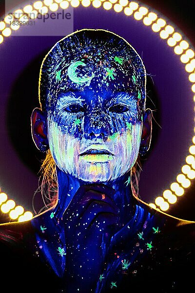 Porträt eines schönen Mädchens mit ultravioletter Farbe im Gesicht. Mädchen mit Neon-Make-up in Farbe Licht